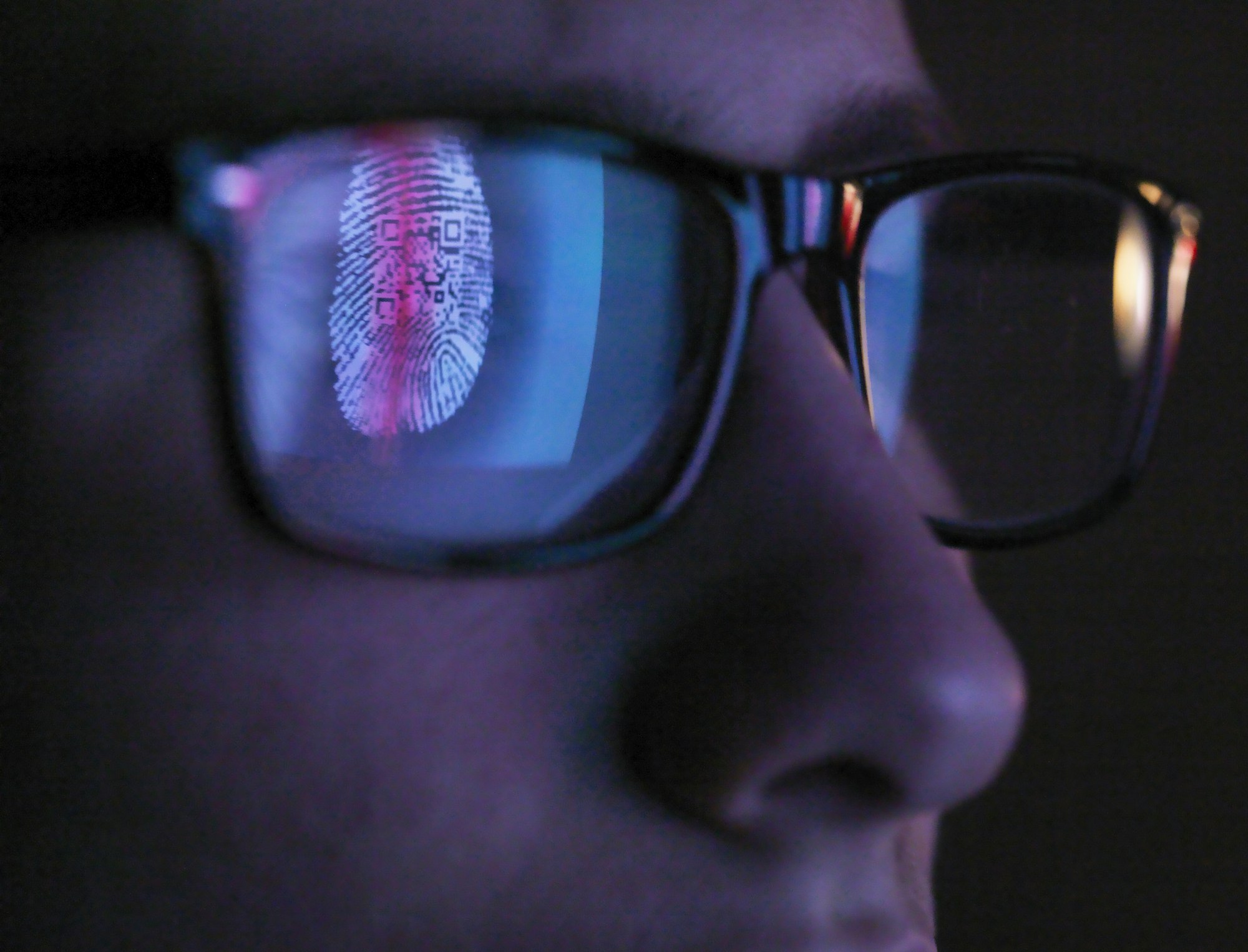 Cyber Security, reflection in spectacles of access information being scanned on computer screen